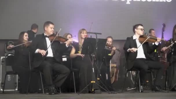 Yekaterinburg, Rússia-agosto de 2019: Orquestra toca violino no palco. Acção. Orquestra com jovens músicos profissionais tocando violinos se apresenta em evento no palco — Vídeo de Stock