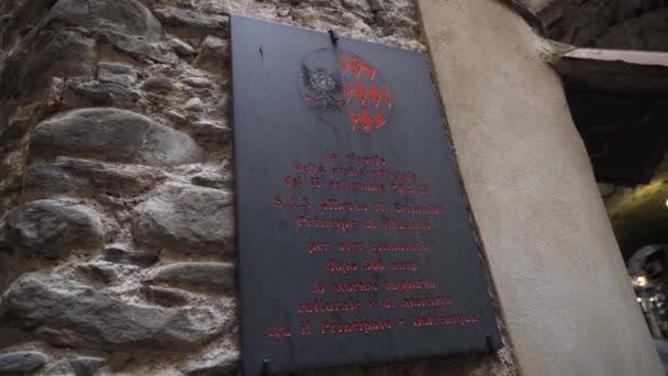 Schild mit Inschriften am Eingang zur Burg. Aktion. schöne schwarze Gedenktafel mit historischen Fakten am Eingang zur alten Burg oder Festung — Stockvideo