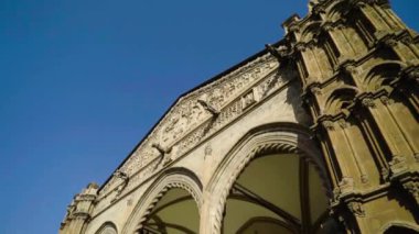 Gökyüzünün arka planında eski mimari binaların kuleleri olan güzel kemerli bir geçit. Başla. Kulesi ve mahzeni olan ayrıntılı mimari bina Avrupa turistik merkezi