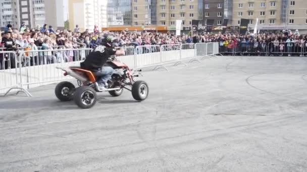 Jekaterynburg, Rosja-sierpień 2019: Człowiek na quadzie wykonuje sztuczki. Akcja. Profesjonalne manewry motocyklistów freestyle na placu przed tłumem widzów za płotem — Wideo stockowe