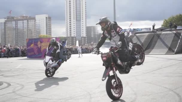 Ekaterimburgo, Rusia-agosto de 2019: Dos motociclistas en el espectáculo freestyle. Acción. Par de rendimiento de los motociclistas en el espectáculo de estilo libre en el fondo de la multitud de personas — Vídeo de stock