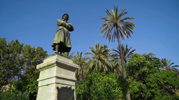 Monumento de homem em pedestal em fundo de árvores verdes e céu. Acção. Vista inferior da bela estátua do homem no fundo de palmeiras e céu azul — Fotografia de Stock