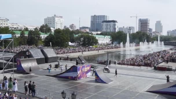 Yekaterinburg, Rusya-Ağustos 2019: Şehirde serbest stil gösterisinde motosikletçi. Başla. Şehrin arka planındaki sıçrama tahtasından uçan tehlikeli motosiklet gösterileri. — Stok video