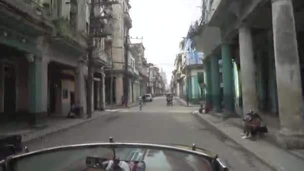 La Habana, Cuba - Mayo, 2019: Vista desde el auto conduciendo en viejas calles sucias con gente. Acción. El coche está acelerando a lo largo de la calle residencial de barrio pobre en el sur de la ciudad — Vídeo de stock
