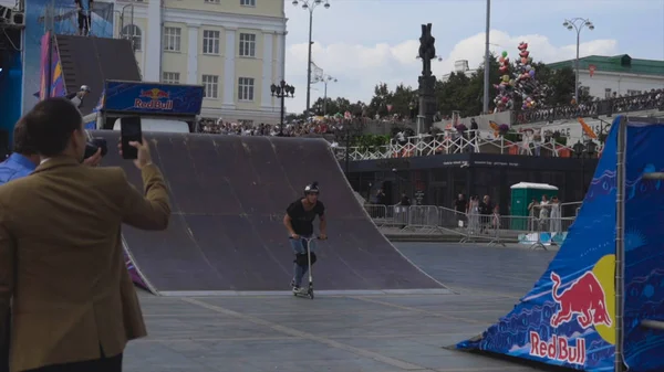 Yekaterinburg, Rusland-augustus 2019: Stuntman op scooter. Actie. Jongeman rijdt professioneel scooter van trampolines en voert trucs. Scooter voor freestyle show — Stockfoto