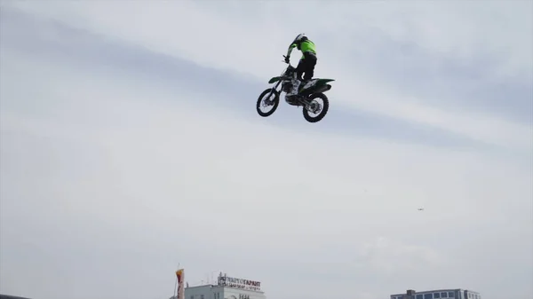 Yekaterinburg, Russia-August, 2019: Motorcyclist at freestyle show in city. Action. Large scale spectacle of dangerous stunts of motorcyclist flying from springboard on background of city — Stock Photo, Image