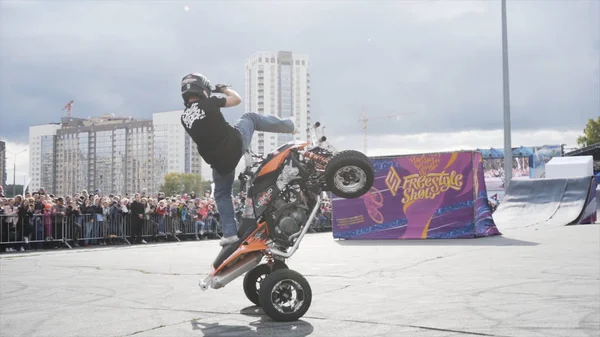 Ekaterinbourg, Russie-Août, 2019 : L'homme est en VTT effectue des cascades. L'action. Cavalier professionnel quad montre des astuces sur fond de foule derrière la clôture — Photo