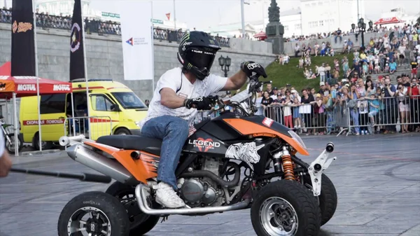 Ekaterimburgo, Rusia-agosto de 2019: Man on Quad bike realiza trucos. Acción. Maniobras profesionales de motociclistas freestyle en la plaza delante de la multitud de espectadores detrás de la cerca —  Fotos de Stock