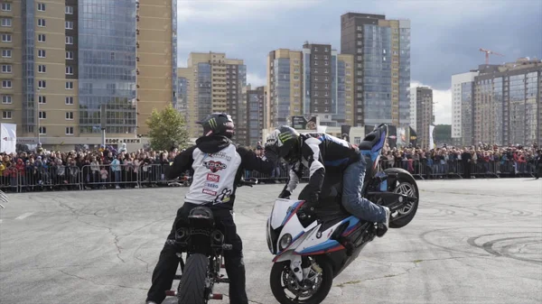 Yekaterinburg, Rusland-augustus 2019: Twee motorrijders op freestyle show. Actie. Paar prestaties van motorrijders op freestyle show op achtergrond van menigte van mensen — Stockfoto