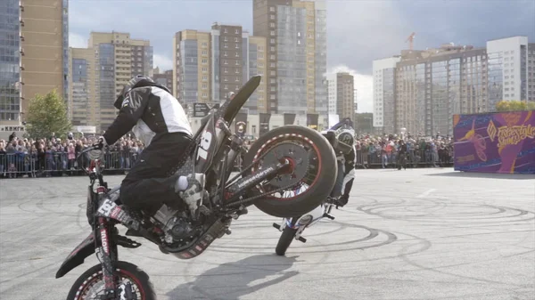 Yekaterinburg, Rusland-augustus 2019: Twee motorrijders op freestyle show. Actie. Paar prestaties van motorrijders op freestyle show op achtergrond van menigte van mensen — Stockfoto