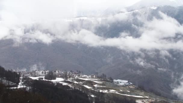 Vista aérea del bosque de pinos de invierno y niebla que cubre las laderas de las montañas en temporada de invierno. Imágenes de archivo. Pequeña ciudad situada en las montañas . — Vídeo de stock