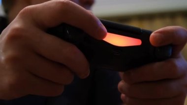 Parmaklarınızı joystick 'e bastırın. Kavram. Heyecanlı erkekler siyah oyun kumandasının düğmelerine tıklayarak neon ışıklı parmaklar