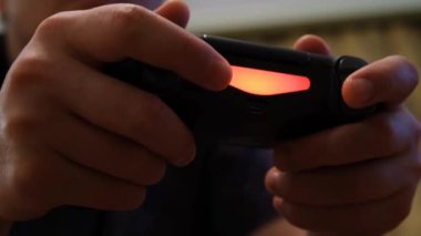Parmaklarınızı joystick 'e bastırın. Kavram. Heyecanlı erkekler siyah oyun kumandasının düğmelerine tıklayarak neon ışıklı parmaklar