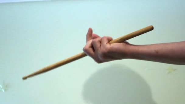 Rotierender Drumstick in der Hand. Konzept. Nahaufnahme eines professionellen Schlagzeugers, der virtuos Drumstick in der Hand auf weißem Hintergrund wirbelt — Stockvideo