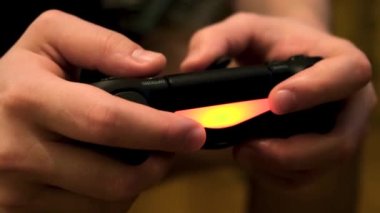 Erkek eller joystick 'i tutuyor, konsolda video oyunları oynuyor, eğleniyor. Kavram. Oyun sahasındaki düğmelere, oyun bağımlılığına ve ev eğlencesi konseptine....