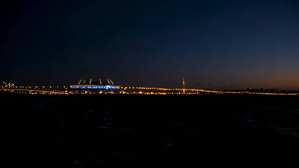 Avondgouden wazig licht van de brug bij de rivier. Concept. Grote stad bokeh brug lichten uit focus op een rivier 's nachts. — Stockfoto