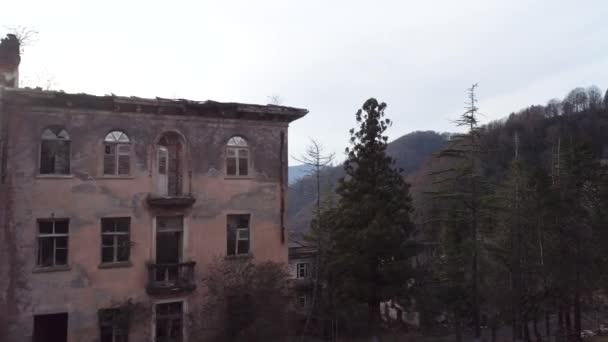 Vecchio mattone distrutto edificio nel tardo autunno stagione. Gli hanno sparato. Casa residenziale senza tetto di mattoni rossi in zona boscosa e montagnosa . — Video Stock