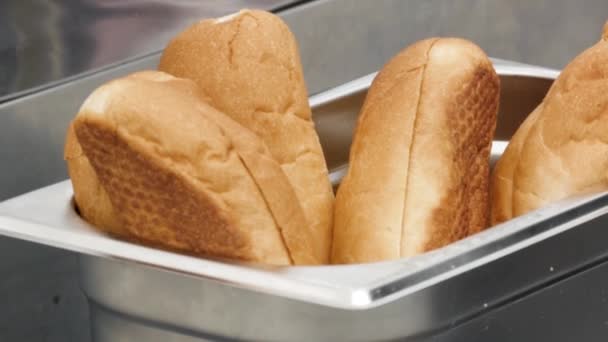 Close up of freshly baked bread buns inside metal metal container. Stock footage. Tasty soft bread for making sandwiches, flour products concept. — Stock Video