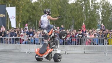 Yekaterinburg, Russia-August, 2019: Man on Quad bike performs tricks. Action. Professional stunt rider on Quad bike performs acrobatic stunts on background of crowd at freestyle show