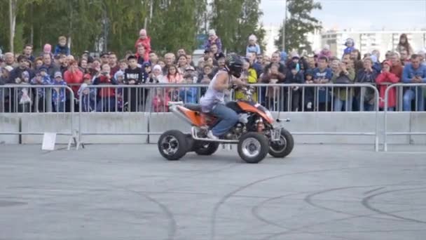 Man op Quad fiets drift. Actie. Professionele drift op Quad bike maakt deel uit van freestyle show. Freestyle show met trucs op Quad fiets in de achtergrond van menigte — Stockvideo