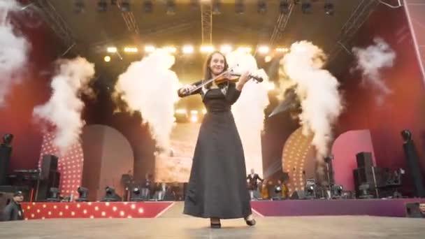 Ekaterimburgo, Rusia-agosto de 2019: Hermosa joven tocando el violín en el escenario. Acción. Violinista toca maravillosamente en el escenario abierto de las ciudades durante el festival — Vídeos de Stock