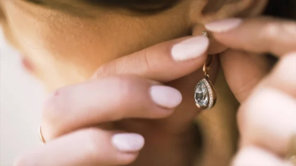 Beautiful woman puts on beautiful earrings. Action. Close up of woman hands touhing her earring with diamonds, jewelry concept. — 스톡 사진