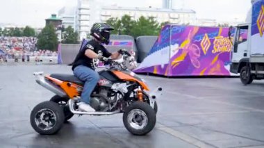 Yekaterinburg, Russia-August, 2019: Man on Quad bike performs stunts. Action. Beautiful performance of rider on background of crowd of people on holiday with freestyle show