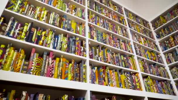 Boekenplank met veel kleurrijke boeken in patronen. Actie. Boeken met kleurrijke patroonhoezen zijn stijlvol geplaatst op planken van groot rek — Stockvideo