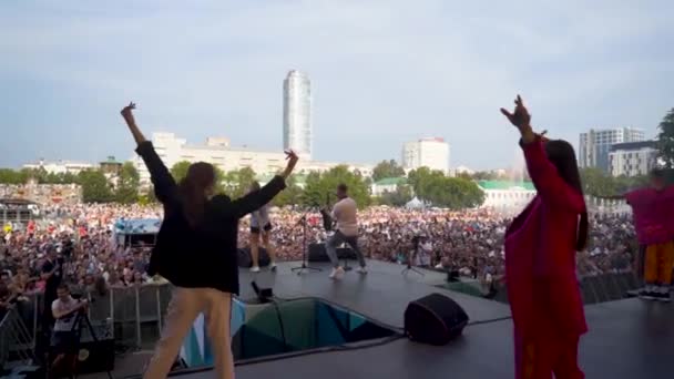 Yekaterinburg, Russia-August, 2019: Performance of artists with group of dancers on background of crowd. Action. Rear view of dancers at concert of summer festival — стокове відео