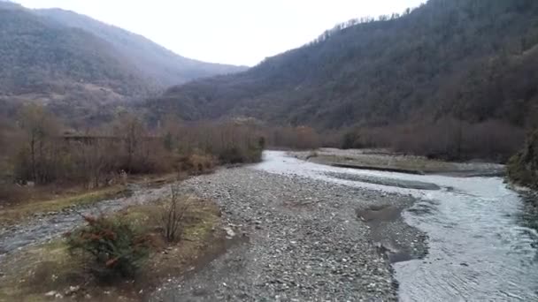 Montaña río angosto y costa pedregosa a lo largo de altas montañas boscosas. Le dispararon. Paisaje aéreo otoñal, laderas anaranjadas de la colina y el flujo rápido de frío . — Vídeos de Stock