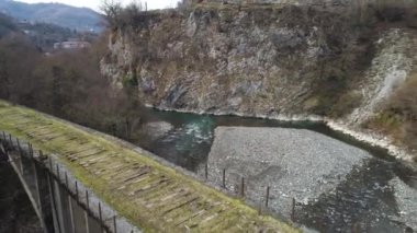 Uçurumun kenarındaki soğuk derenin üzerindeki terk edilmiş eski taş köprünün dağlık manzarası. Vuruldu. Köprünün üzerinden uçmak hiçbir yere varmıyor..