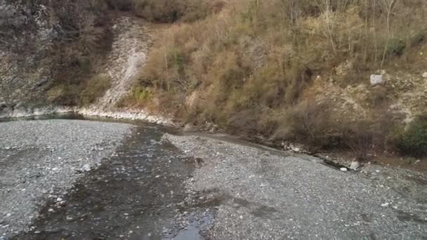 Montaña río angosto y costa pedregosa a lo largo de altas montañas boscosas. Le dispararon. Paisaje aéreo otoñal, laderas anaranjadas de la colina y el flujo rápido de frío . — Vídeos de Stock