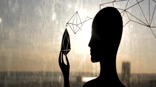 Female black silhouette against glass window with a strange object in her hand. Stock footage. Sun shining through the female shape, the third eye and soul enlightenment concept. — Stock Video