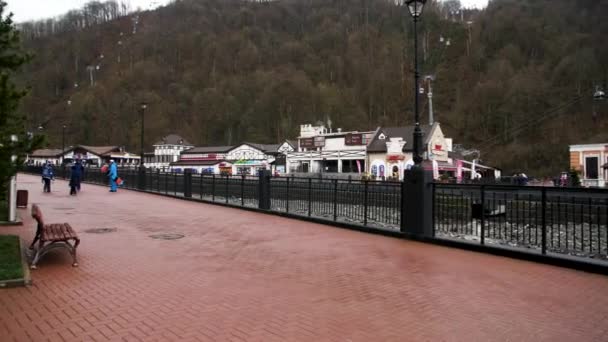 Hermoso paisaje de la estación de esquí, pavimento con gente que camina y se mueve funicular. Imágenes de archivo. Increíble ciudad montañosa con colinas boscosas a finales de la temporada de otoño . — Vídeo de stock