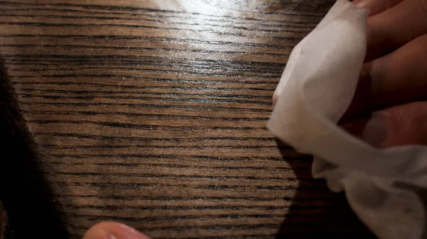 Mannelijke hand die houtverzorgingsproducten aanbrengt op een houten bord met witte doek. Voorraadbeelden. Sluiten van houten paneel olieverf proces. — Stockfoto