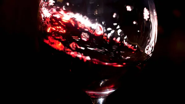 Kırmızı şarap, siyah arka planda şarap bardağına dökülüyor. Stok görüntüleri. Bardağa alkollü içecek dökmeye devam et.. — Stok fotoğraf