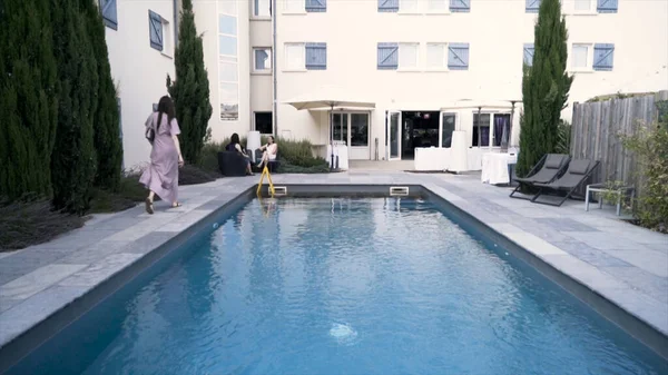 Privé zwembad in de buurt van hotel, zonnige zomer reizen en vakantie concept. Actie. Helder blauw water in het buitenzwembad bij het hotelgebouw. — Stockfoto