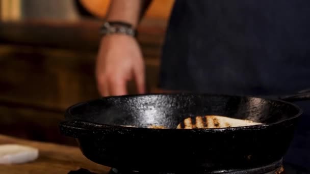 Des petits pains frais faits maison pour des hamburgers frits dans une poêle. Images d'archives. Gros plan des mains du chef masculin appuyant sur les pains à hamburger pendant la friture, processus de préparation du hamburger . — Video