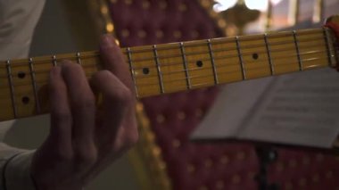 Gitarist elin konser, sanat ve müzik konsepti sırasında gitar akorları çalmasını kapat. Stok görüntüleri. Etkinlikte beyaz gömlekli erkek müzisyen sarı boyunlu elektro gitar çalıyor..