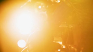 Işığın arka planındaki borular ve parçalar. Stok görüntüleri. Parlak sarı ışığın arka planında karmaşık borular ve demir parçalar var.