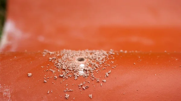 The professional worker using drill to make a hole in a red roof tile, construction concept. Stock footage. Industrial worker with professional equipment. — Stockfoto