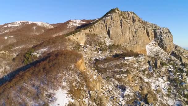 Prachtige rots in zonlicht op achtergrond van blauwe lucht in de winter. Neergeschoten. Rotsachtige landschappen van grote natuur op heldere winterdag zal iedereen fascineren met hun krachtige schoonheid — Stockvideo
