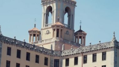 Avrupa 'nın eski klasik mimarisi. Beyaz renkli tarihi bina cephesi, şehir sokak manzarası. Başla. Tepesinde bir kule ve süsleme olan güzel beyaz bir bina..