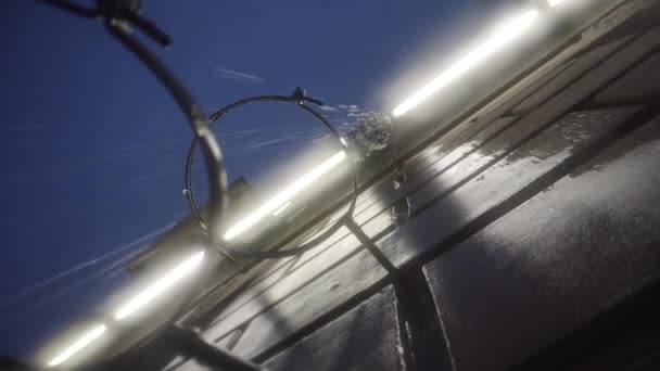 Bottom view of the building wall and a drainpipe during heavy rain on late evenin sky background. Motion. Details of city architecture, close up of brick house wet wall. — Wideo stockowe