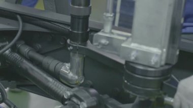 Fabrikada vidaları olan araba parçaları montajı. Sahne. Modern fabrikada arabanın içindeki vidaları sıkılaştırmak. Araba motoru montajı