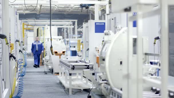 Worker checks processes in modern equipped enterprise. Scene. Factory worker checks and monitors maintenance of shop with white and clean equipment in enterprise — Stock Video