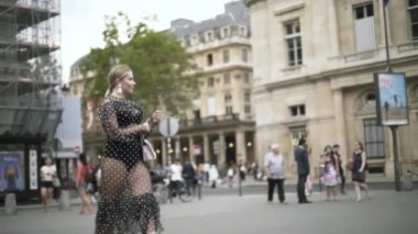 Siyah noktalı seksi elbise ve beyaz küçük çanta giyen şık Avrupalı kadın, Paris, Fransa. Başla. Sarışın, büyük beden manken sokakta yürüyor..