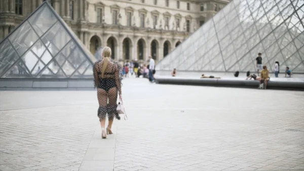 Chica en vestido extravagante sexy y ropa interior negra caminando cerca del museo del Louvre en París, Franc. Acción. Increíble modelo de tamaño más posando delante de la cámara . —  Fotos de Stock