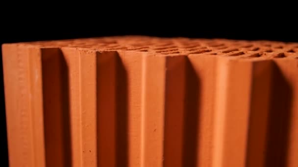 Närbild av perforerade keramiska block med runda hål isolerade på svart bakgrund. Lagerbilder. Material för byggande av nytt tegelhus. — Stockvideo