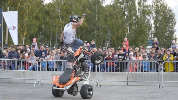 Yekaterinburg, Russia-August, 2019: Man on Quad bike performs tricks. Action. Professional stunt rider on Quad bike performs acrobatic stunts on background of crowd at freestyle show — Stockfoto
